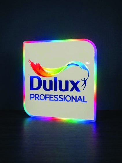 Signage akrilik dengan logo brand dan lampu LED